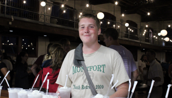 A smiling student takes a soda