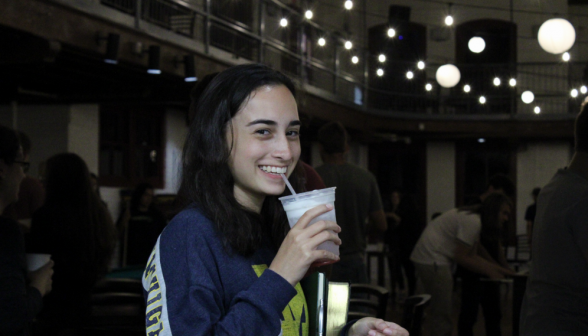 Closeup of a happy student sipping their Italian soda