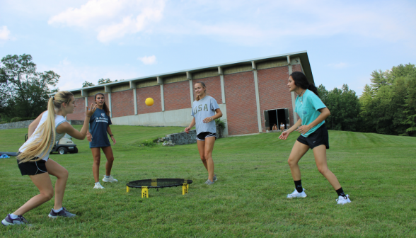 A game of Spikeball afront the athletic center