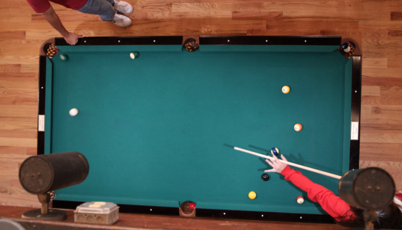Vertical shot of the pool table: a shot has just been made, and green solid is headed for the pocket!