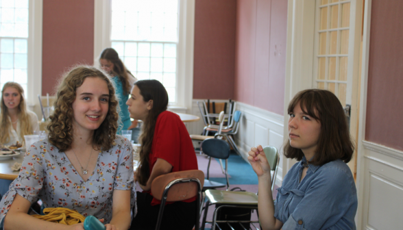 Two students seated at one of the tables