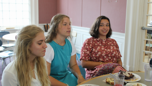 Three students with their lunches at a table