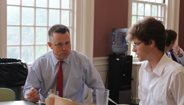 Directory of Admissions Jon Daly eats while chatting with a student