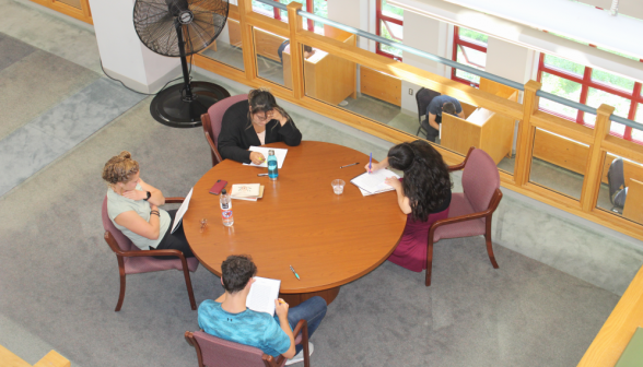 Overhead view of four students at a round table on the library's main level