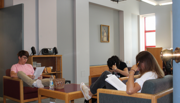 Three in armchairs around a square table in the music room, afront the CD player