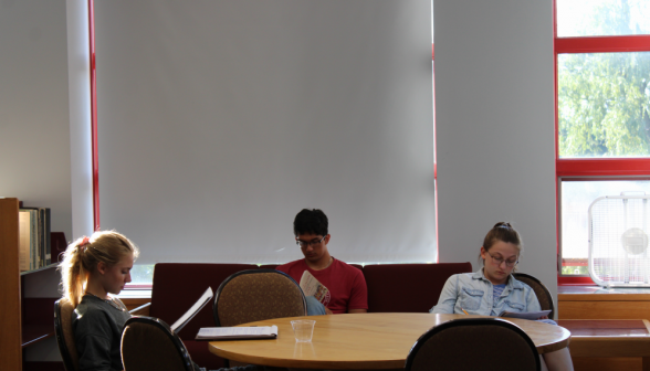 Students around a table in one of the side rooms