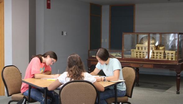 Three studying afront the gold-plated replica of King Solomon's Temple