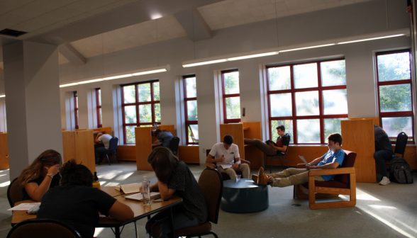 The bottom floor of the library, with students at every study desk and table