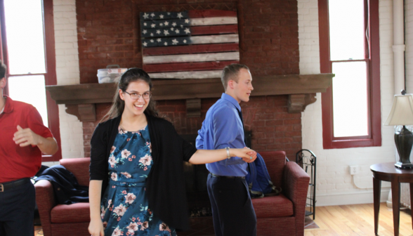 A pair of students take their places afront the fireplace