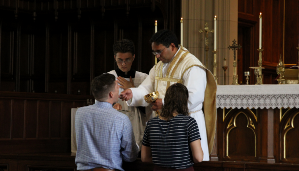 Fr. Miguel gives Communion to a staff member