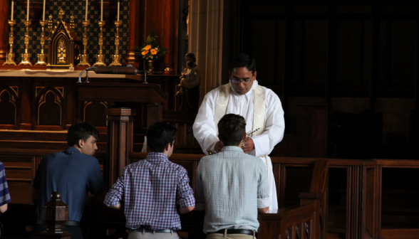 Another view of Fr. Miguel holding the relic for veneration