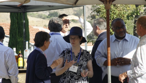 Attendees talking under a sun shade