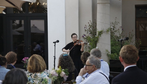A violinist performs for the attendees