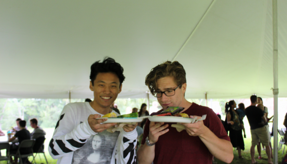 Two students pose with their plates laden with food