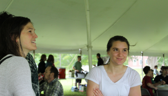 A prefect chats with a staff family member under the shade