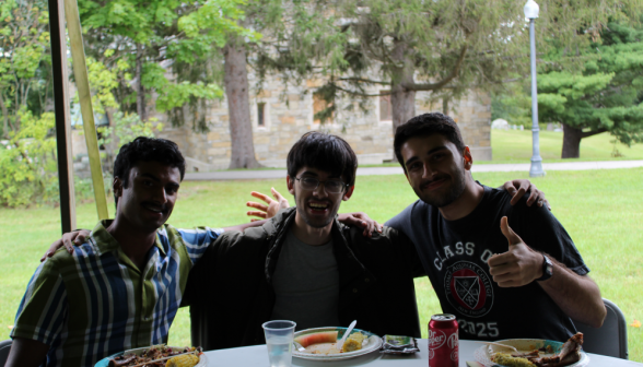 Three students in silhouette give a "thumbs up" over their food