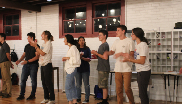 Students clapping along the east wall