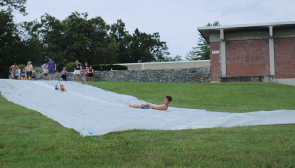 Two students sliding down the slip-n-slide