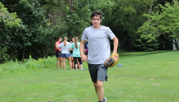 A student jogs along, catcher's glove in hand