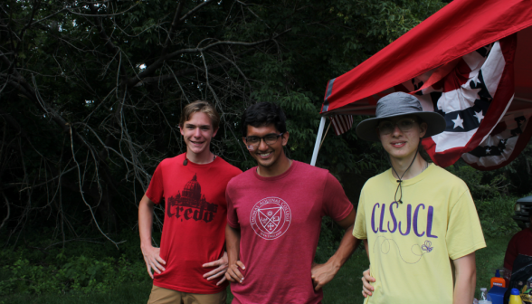 Two students pose with a prefect afront a shade with bunting