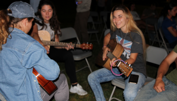 Three students with guitars in a ring