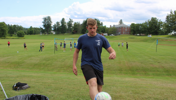 David Carey kicks a ball at the edge of the field