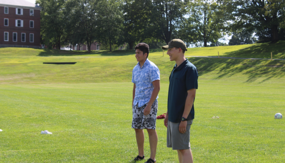 Two students standing at the edge of the field