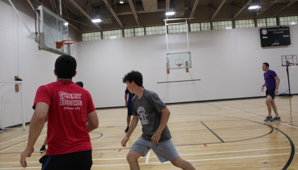 Students running near the basket on one side. The ball is not visible.