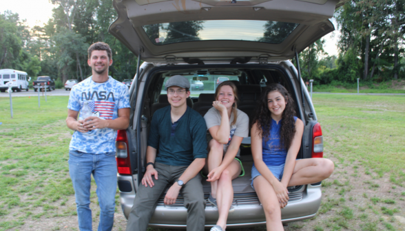 TAC summer workers seated on the tailgate of a minivan