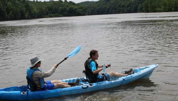 Two students in a blue kayak