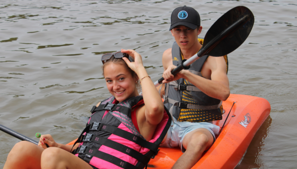 Two students in an orange kayak, overhead shot