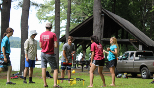 A game of Spikeball afront a small sheltered table area