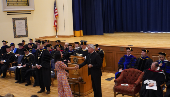 Another student shakes the Bishop's hand