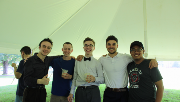 Five students pose for a photo, floats in hand