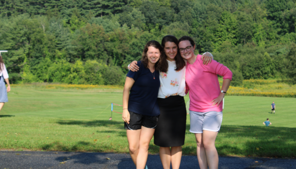 Two students pose with a prefect for a photo