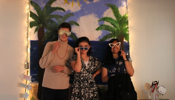 Three students pose with extravagant costume glasses