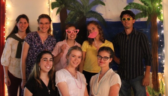 Eight students pose together, some with the enormous glasses