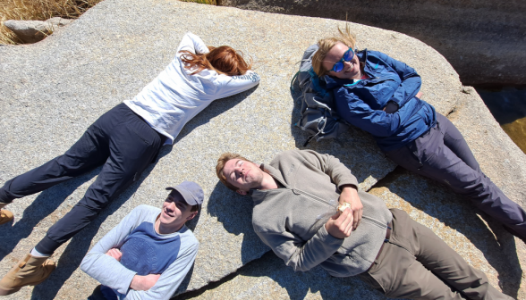 Students lie down and relax atop a flat rock
