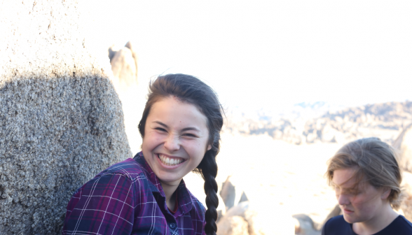 A student grins at the camera amid blinding sunlight