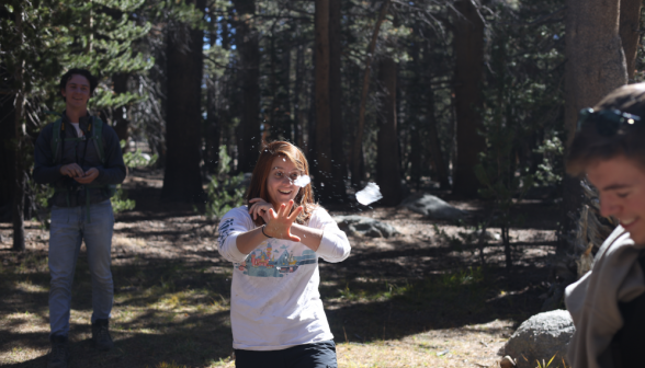 A student attempts to catch something blurry flying through midair