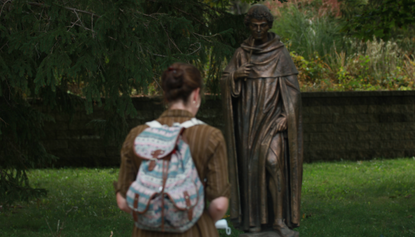 A student prays afront one of the statues