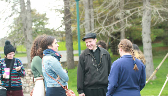 Laughing, Fr. Markey talks with some of the students