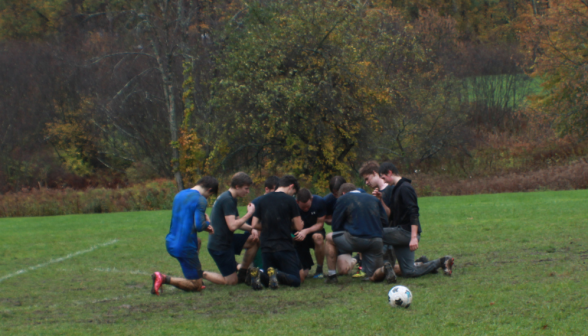 Students pray on soccer field