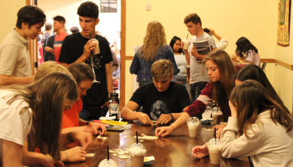 At a long table, students drink milkshakes and play Bananagrams
