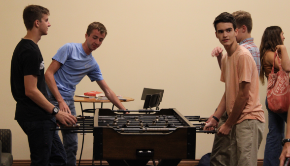 Students play 2v2 foosball