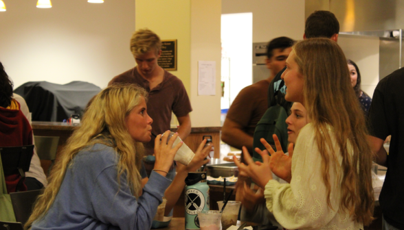 An animated discussion occurs at a small round table over milkshakes