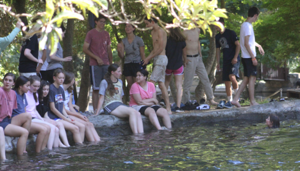 Programmers sit on the edge, swishing their feet in the water