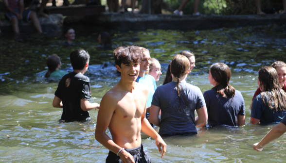 A student in the foreground looks at the camera