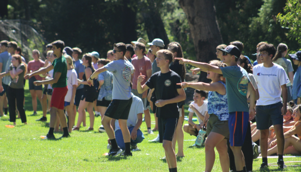 Groups of students on the side of the athletic field