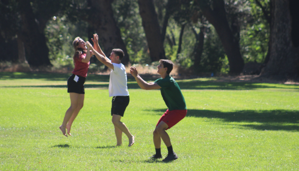 Two give a double high-five while a third prepares to catch the ball